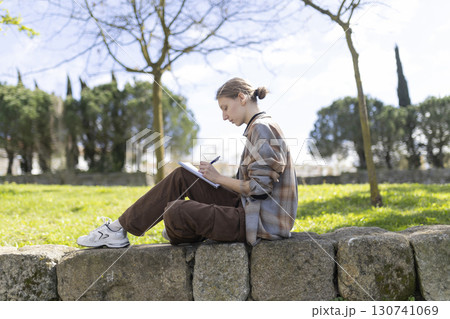 Young artist drawing outdoors in a park: finding inspiration in nature 130741069