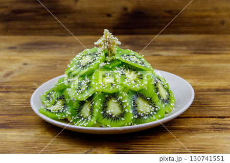 Christmas tree shaped fruit salad on wooden table. Creative idea for Christmas and New Year festive desserts. Funny food idea for kids 130741551