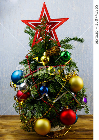Small decorated Christmas tree on a table in a room Small decorated Christmas tree on a table in a room 130741565