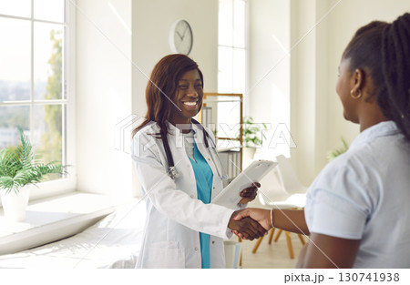 Compassionate Black Doctor Greets Patient with Handshake Compassionate Black Doctor Greets Patient with Handshake 130741938