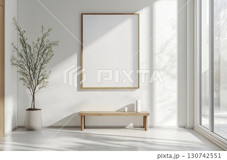 Sunlight illuminating a modern, minimalist interior design featuring a blank customizable frame, potted plant, wooden bench, and large window 130742551