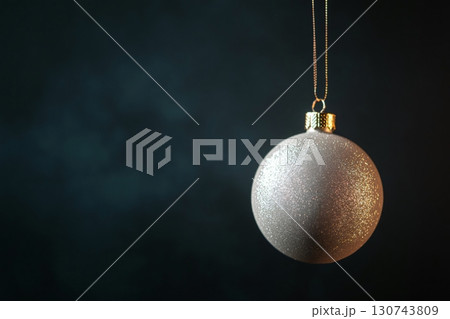 Beautiful silver Christmas ornament hangs elegantly against a dark background, sparkling with glitter and adding holiday magic. Perfect for festive designs with copy space Beautiful silver Christmas ornament hangs elegantly against a dark background, sparkling with glitter and adding holiday magic. Perfect for festive designs with copy space 130743809