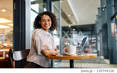 A Young Professional is Thriving while Successfully Working in a Modern and Vibrant Cafe Setting 130744126