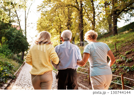 A Family Enjoying a Leisurely Walk in a Beautiful and Scenic Park This Autumn Season 130744144