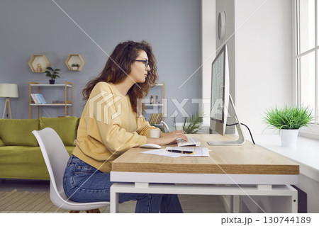 Young woman accountant is working from home and using spreadsheets on her computer Young woman accountant is working from home and using spreadsheets on her computer 130744189