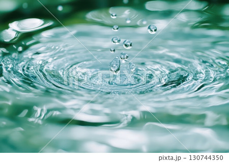 Capturing water droplets creating ripples in a serene natural setting 130744350