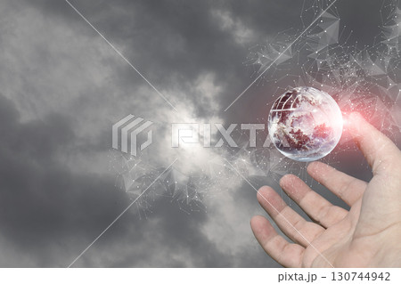 Hand reaching for a digital globe in cloudy sky. 130744942