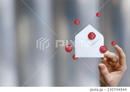 Creative envelope held amidst floating virus illustrations Creative envelope held amidst floating virus illustrations 130744944