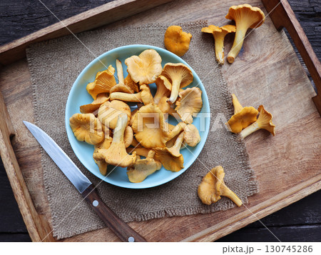Bowl of chanterelle mushrooms on wooden background 130745286