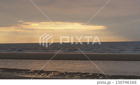 Sunset on the beach near beautiful sea in the evening. Yellow sunlight. Vacation in Ostend, Belgien. Nature background. Sunset on the beach near beautiful sea in the evening. Yellow sunlight. Vacation in Ostend, Belgien. Nature background. 130746168