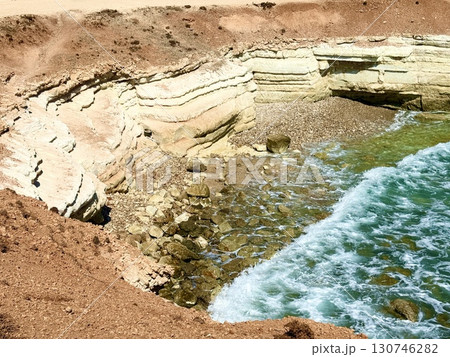 Public beach, summer, beautiful sunny weather. Picturesque beach, waves crashing on the sandy shore. Sea waves beat against the rocks. Cyprus Island, umbrellas, tourist boats, Mediterranean Sea. Public beach, summer, beautiful sunny weather. Picturesque beach, waves crashing on the sandy shore. Sea waves beat against the rocks. Cyprus Island, umbrellas, tourist boats, Mediterranean Sea. 130746282