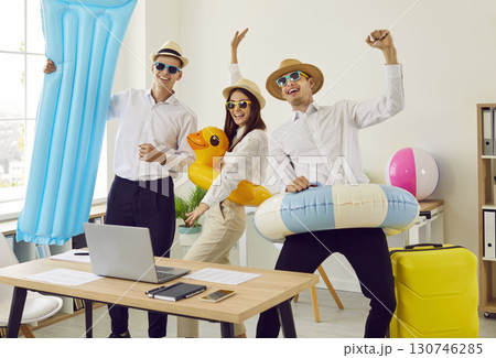 Overjoyed company employees going on summer holidays booking tickets in office. 130746285