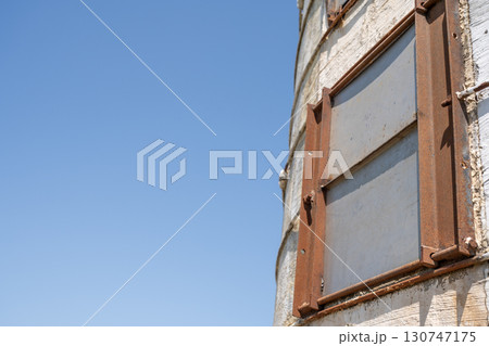 Rusty window on an old silo against a clear blue sky showcases the passage of time in rural america 130747175