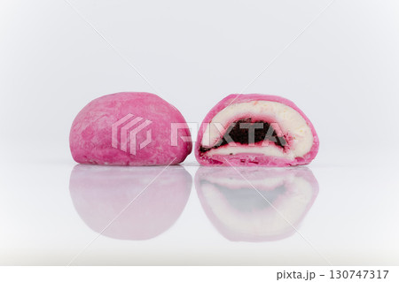 Pink mochi ice cream with berry filling, cut in half, isolated on white background Pink mochi ice cream with berry filling, cut in half, isolated on white background 130747317