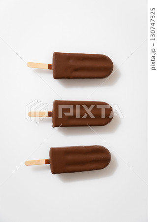 Chocolate ice cream popsicles on white background. Minimalist summer dessert concept Chocolate ice cream popsicles on white background. Minimalist summer dessert concept 130747325