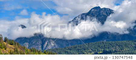 Mountain landscape view with clouds below the mountain's tops 130747548