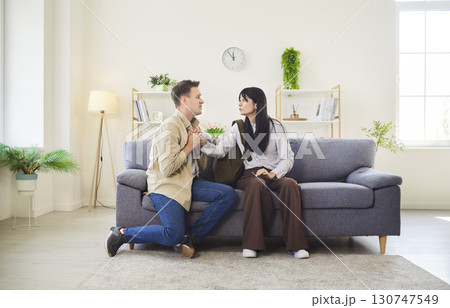 Man and woman in tense conversation on living room sofa with emotion and conflict Man and woman in tense conversation on living room sofa with emotion and conflict 130747549