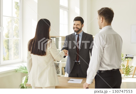 Office confident diverse business people, men and woman shaking hands in office, smiling 130747553