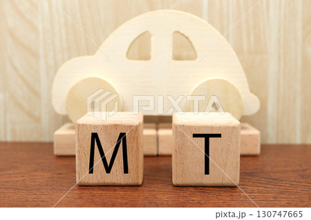 木製のおもちゃの車とMT表記ブロック。マニュアル車のイメージ。 木製のおもちゃの車とMT表記ブロック。マニュアル車のイメージ。 130747665