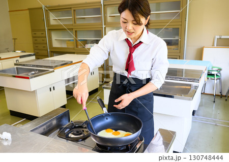 料理教室で指導する女性講師　料理レッスン・食育イメージ 130748444
