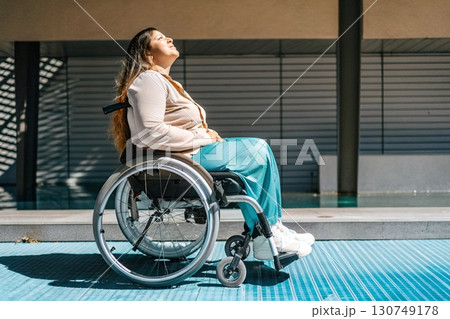 Plus-Size Woman in a Wheelchair Enjoying Sunshine. 130749178