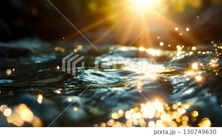 Water droplets capture sunlight on a surface, generating a stunning ripple effect that embodies the spirit of Earth Day 130749630