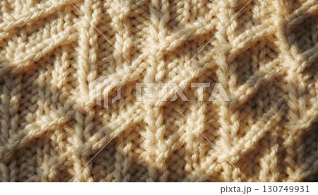A close-up of a textured knitted sweater, with sunlight enhancing the intricate knit design 130749931