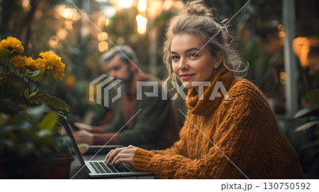 Woman Using Laptop in Botanical Garden with Bokeh Background 130750592