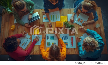 Business Women Analyzing Graphs During Office Meeting 130750629