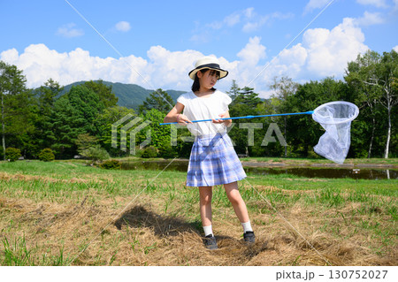 青空の下で虫取りを楽しむ女の子 130752027