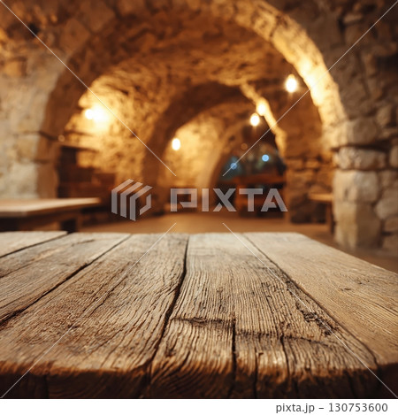 Rustic Mediterranean stone interior with wooden table and warm vintage lighting 130753600
