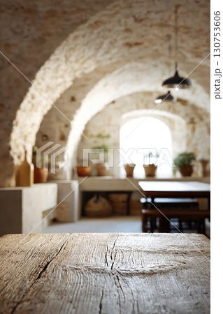 Rustic Mediterranean stone interior with wooden table and warm vintage lighting 130753606