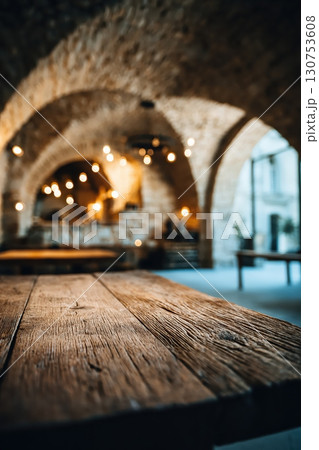 Rustic Mediterranean stone interior with wooden table and warm vintage lighting 130753608