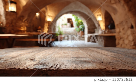 Rustic Mediterranean stone interior with wooden table and warm vintage lighting 130753612