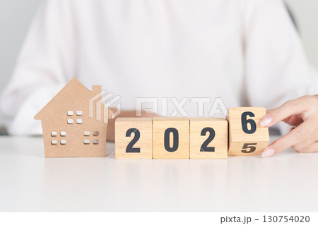 2025 end year to Happy New Year 2026 with house model. real estate, Home loan and mortgage, tax, investment, financial, savings and New Year Resolution concepts 130754020