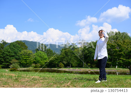 青空の高原でリラックスする主婦 自然・休日・ライフスタイル 青空の高原でリラックスする主婦 自然・休日・ライフスタイル 130754413