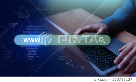 Hands typing on laptop keyboard while searching the web with digital graphics in a modern workspace 130755124