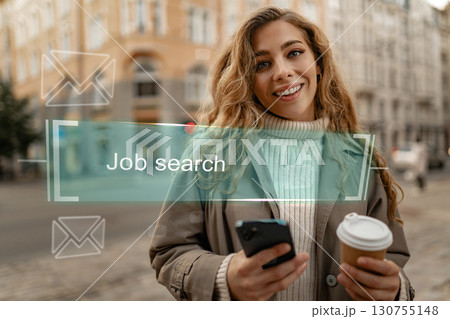 Young woman engaged in job search while enjoying coffee in a city setting on a sunny day 130755148