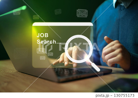 Searching for job opportunities on a laptop in a modern office setting during the evening 130755173