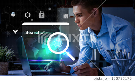 Young man engaged in online research using a laptop in a modern workspace with technology elements Young man engaged in online research using a laptop in a modern workspace with technology elements 130755179
