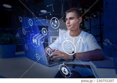 Young professional working on human resources tasks with digital interface in modern office setting 130755207