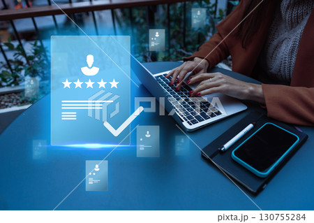 Professional reviewing of digital profiles on a laptop at dusk in a modern workspace with holographic elements Professional reviewing of digital profiles on a laptop at dusk in a modern workspace with holographic elements 130755284