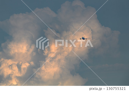 夕焼けに浮かぶ飛行機　背景にさまざまな表情の雲　空　太陽　夕空　朝焼け 130755321