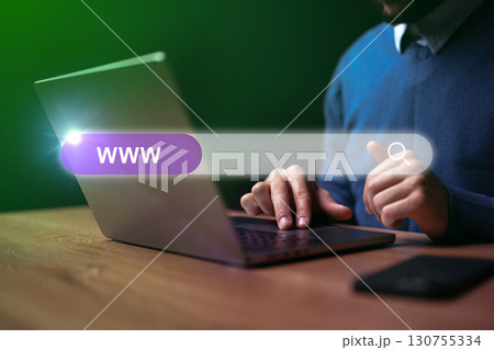 Man browsing the internet on laptop in an indoor setting during evening hours with a focus on search bar Man browsing the internet on laptop in an indoor setting during evening hours with a focus on search bar 130755334