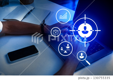 Hands typing on a laptop with digital icons symbolizing data analytics and communication displayed on the screen at night 130755335