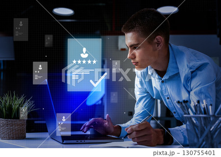 Young professional engaged in digital project review in modern office environment at night Young professional engaged in digital project review in modern office environment at night 130755401