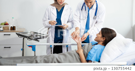 Doctors analyzing results or diagnosis of patient in clinic. Teamwork, medical and healthcare workers in discussion and research on mobile device Doctors analyzing results or diagnosis of patient in clinic. Teamwork, medical and healthcare workers in discussion and research on mobile device 130755442