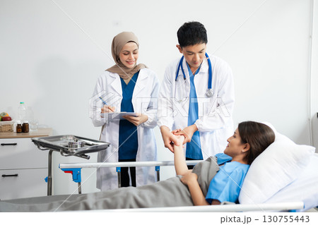 Doctors analyzing results or diagnosis of patient in clinic. Teamwork, medical and healthcare workers in discussion and research on mobile device Doctors analyzing results or diagnosis of patient in clinic. Teamwork, medical and healthcare workers in discussion and research on mobile device 130755443