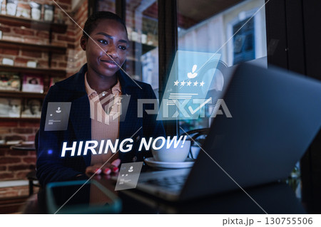Professional woman engaged in job search using laptop in a cozy cafe during afternoon hours Professional woman engaged in job search using laptop in a cozy cafe during afternoon hours 130755506
