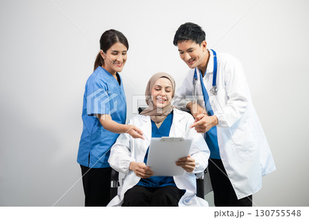 Successful team of medical doctors looking at camera and smiling while standin. Health, professional and people team Successful team of medical doctors looking at camera and smiling while standin. Health, professional and people team 130755548